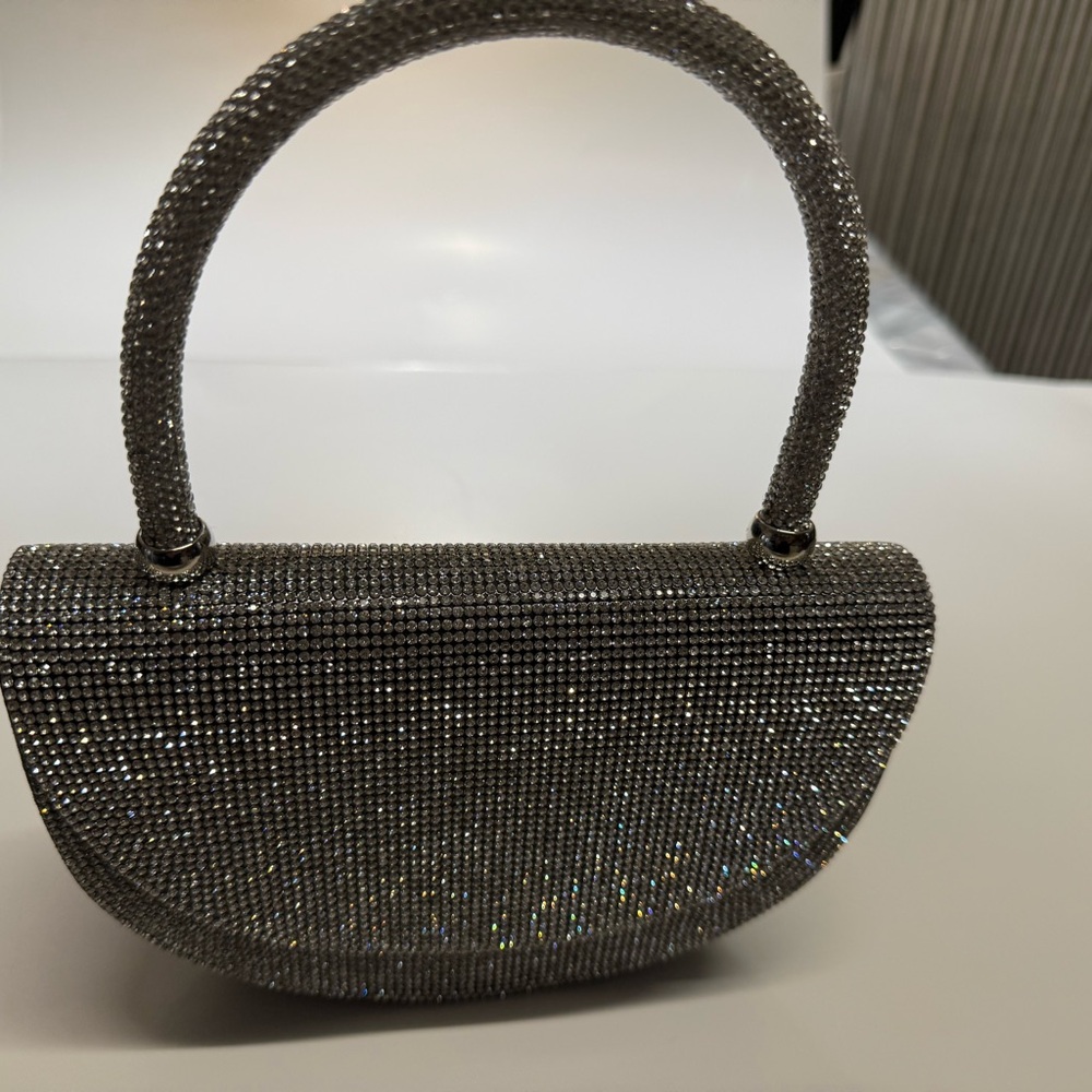 silver shimmery hand bag with handles and chain shoulder strap black sides